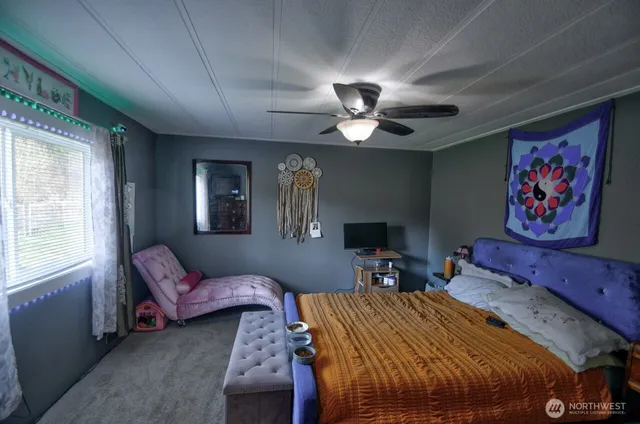 a bedroom with a bed couch and a window