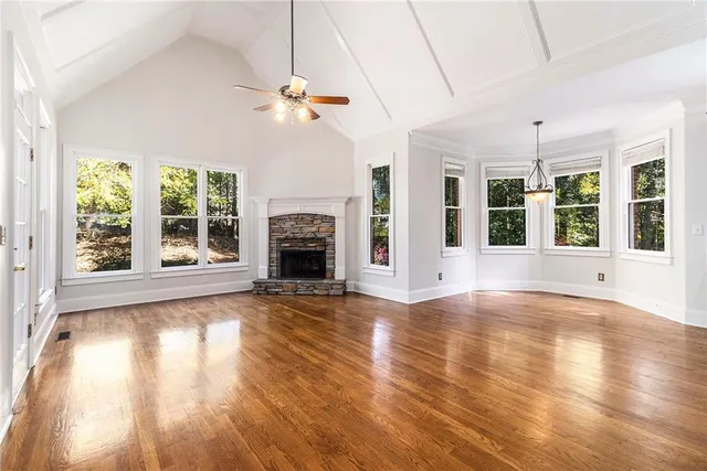 a view of a big room with wooden floor and a kitchen