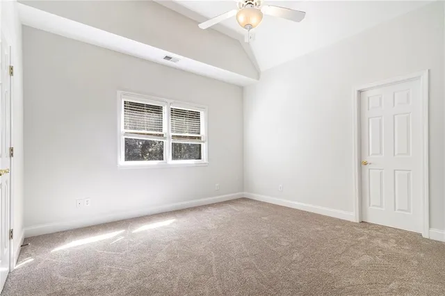 a view of an empty room with a cabinet and a window