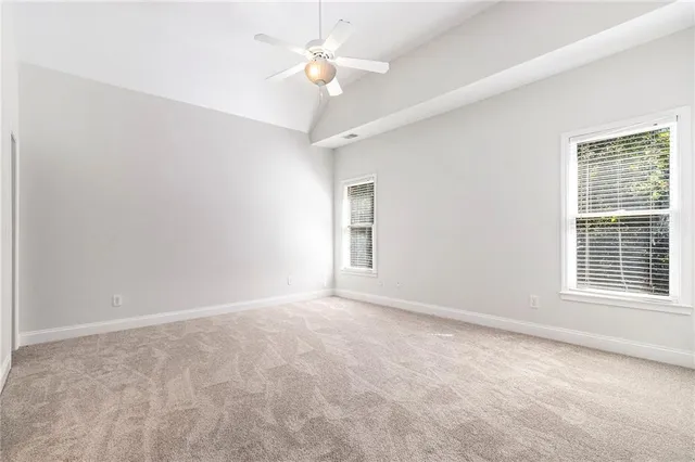 an empty room with a window and a ceiling fan