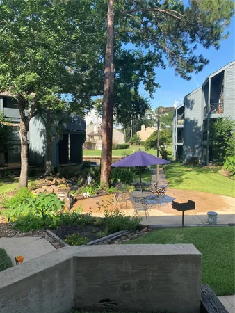 a view of a house with garden and a tree