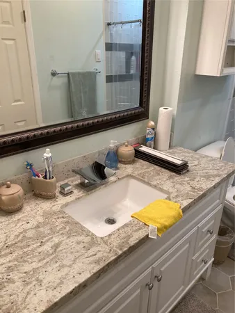 a bathroom with a granite countertop sink and a mirror