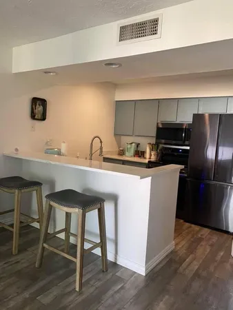 a kitchen with kitchen island a sink stove and refrigerator