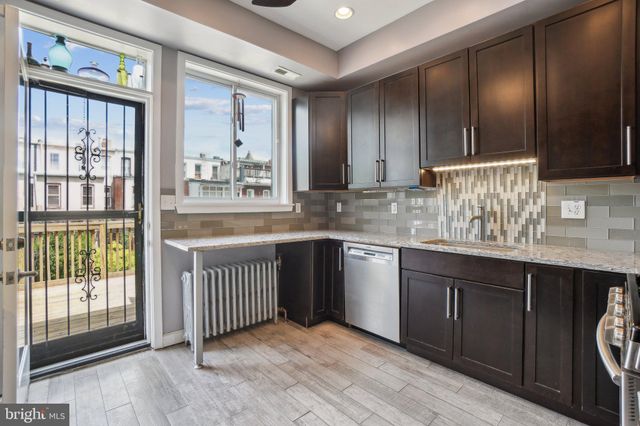 a bathroom with a granite countertop sink and a large mirror