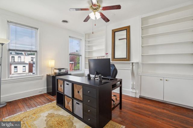 a view of a workspace with furniture and a window