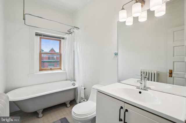 a bathroom with a sink a toilet a mirror and shower