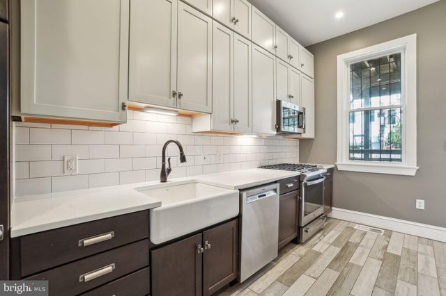 a kitchen with a sink cabinets and window