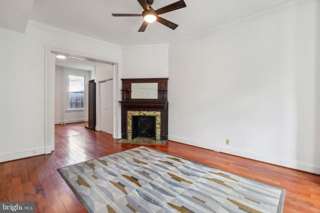 a view of empty room with wooden floor and fireplace