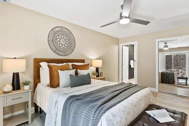 a bedroom with bed and a lamp on dresser