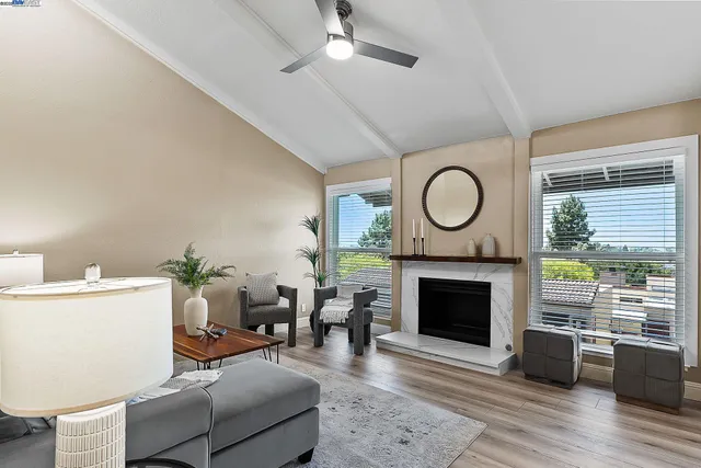 a living room with furniture a fireplace and a large window