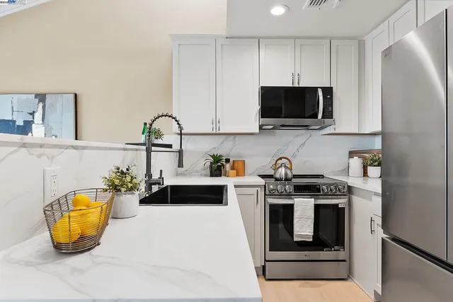 a kitchen with a sink a stove and cabinets