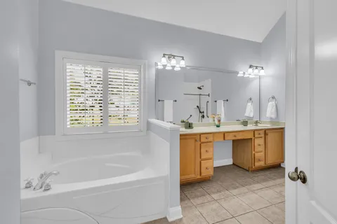 a bathroom with a bathtub sink and a mirror