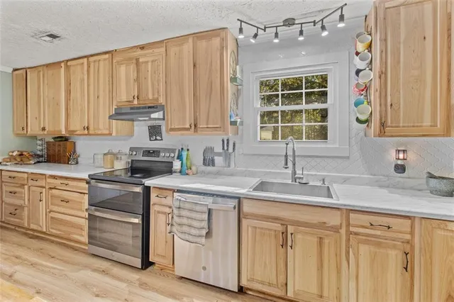 a kitchen with appliances cabinets and a sink