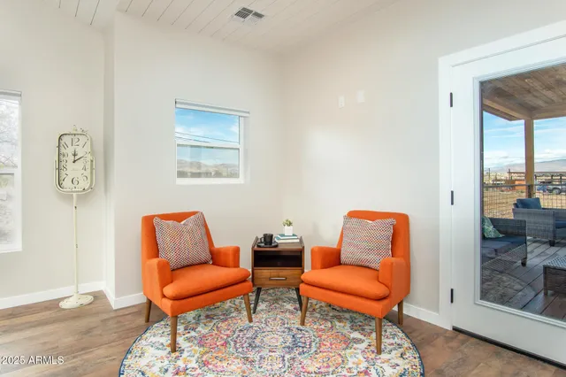 a living room with furniture kitchen view and a chandelier