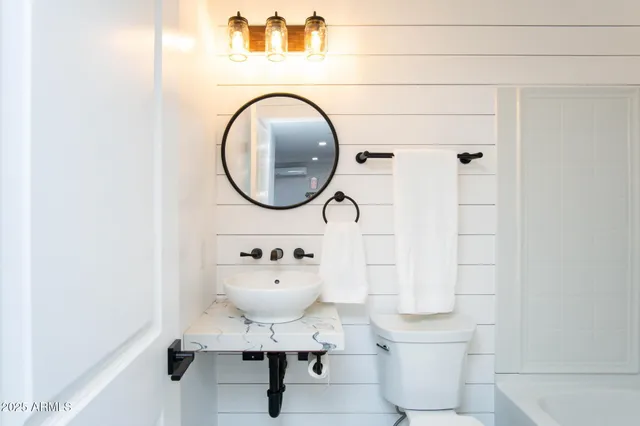 a kitchen with stainless steel appliances granite countertop a stove top oven a sink a dining table and chairs with wooden floor