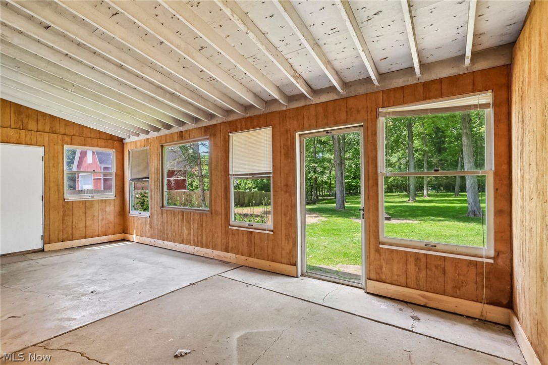 1638 South Cleveland Massillon Road Akron, OH 44321 - Photo 31 of 37 Enclosed patio area featuring wood-paneled walls, exposed beam ceiling, and concrete flooring