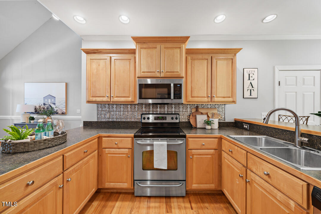 745 Oaks Lane Road Timberlake, NC 27583 - Photo 23 of 38 a kitchen with granite countertop a stove sink microwave and cabinets