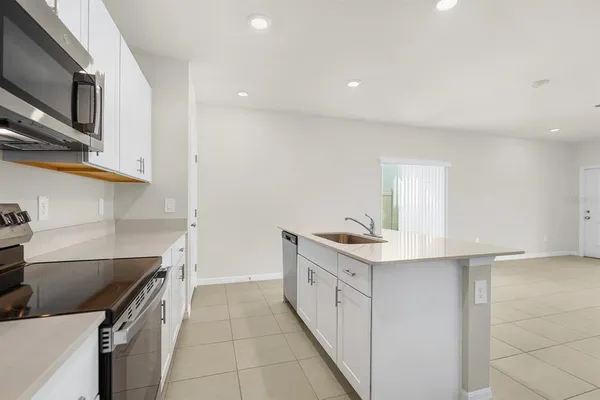 a kitchen with stainless steel appliances granite countertop a sink and dishwasher a refrigerator with white cabinets