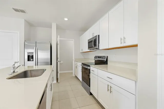 a kitchen with stainless steel appliances a sink and a refrigerator