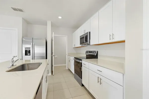 a kitchen with stainless steel appliances a sink and a refrigerator
