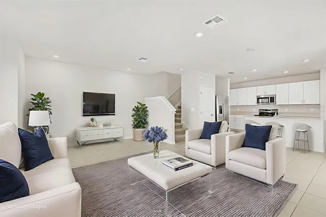 a view of kitchen with refrigerator and white cabinets
