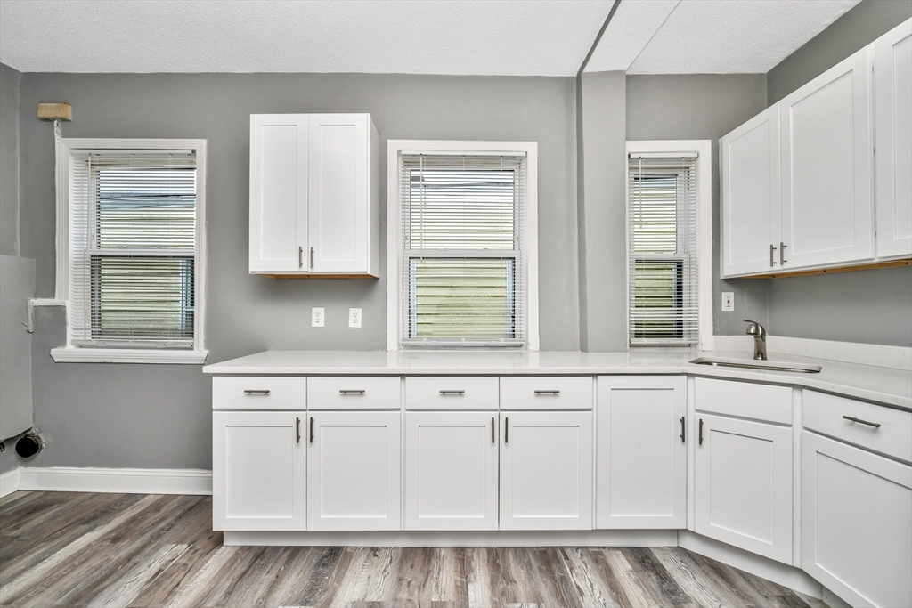 352 Norfolk Street, Unit 3 Boston, MA 02124 - Photo 3 of 12 a kitchen with white cabinets and window