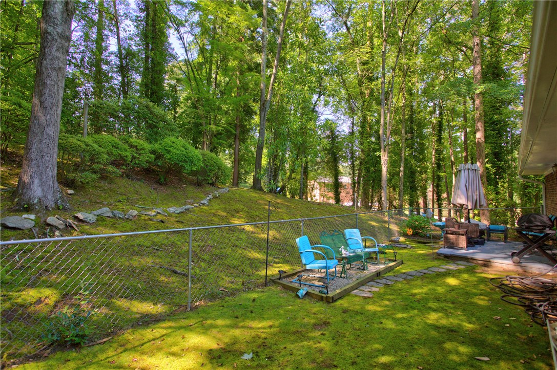 104 Laurel Lane Seneca, SC 29678 - Photo 33 of 36 A tranquil backyard sanctuary with a spacious patio, mature trees, and a terraced lawn.