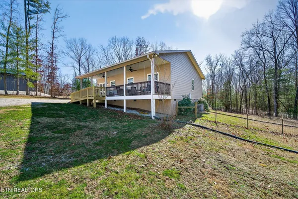 a view of a house with backyard and trees