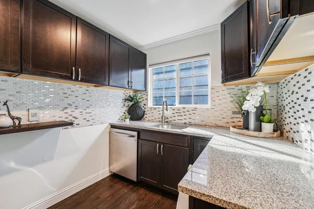 a kitchen with stainless steel appliances granite countertop a sink stove and cabinets