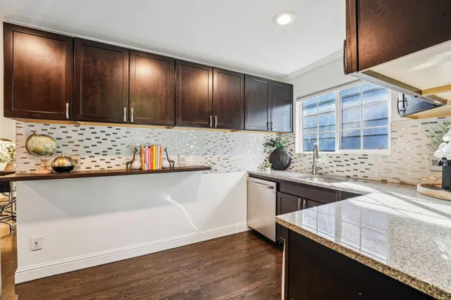 a kitchen with stainless steel appliances granite countertop a sink and a stove