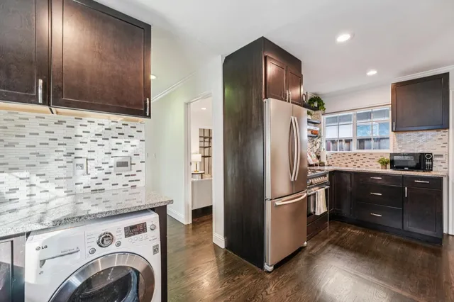 a kitchen with stainless steel appliances granite countertop a refrigerator and a stove top oven