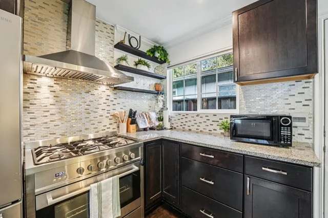 a kitchen with stainless steel appliances granite countertop a stove and a microwave