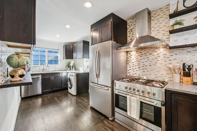 a kitchen with stainless steel appliances a stove a sink a refrigerator and cabinets