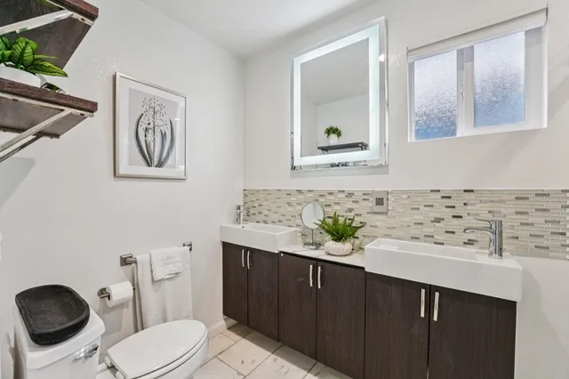 a bathroom with a toilet sink and mirror