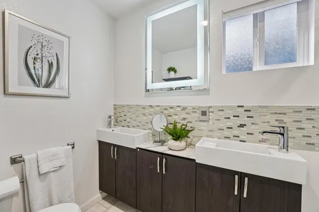 a bathroom with a sink a toilet and a mirror