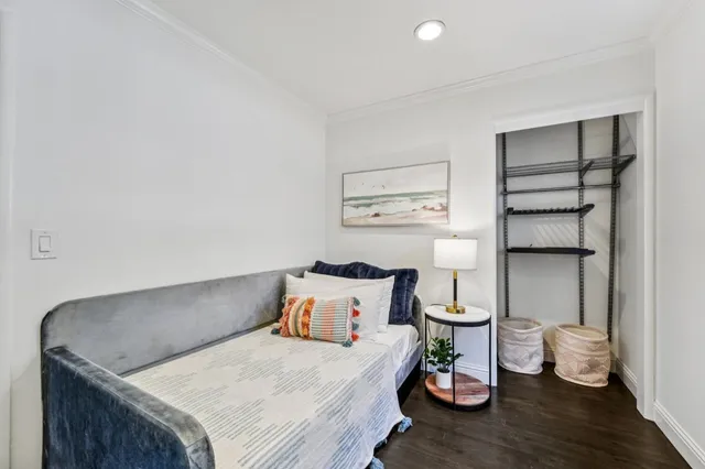 a bedroom with a bed and wooden floor