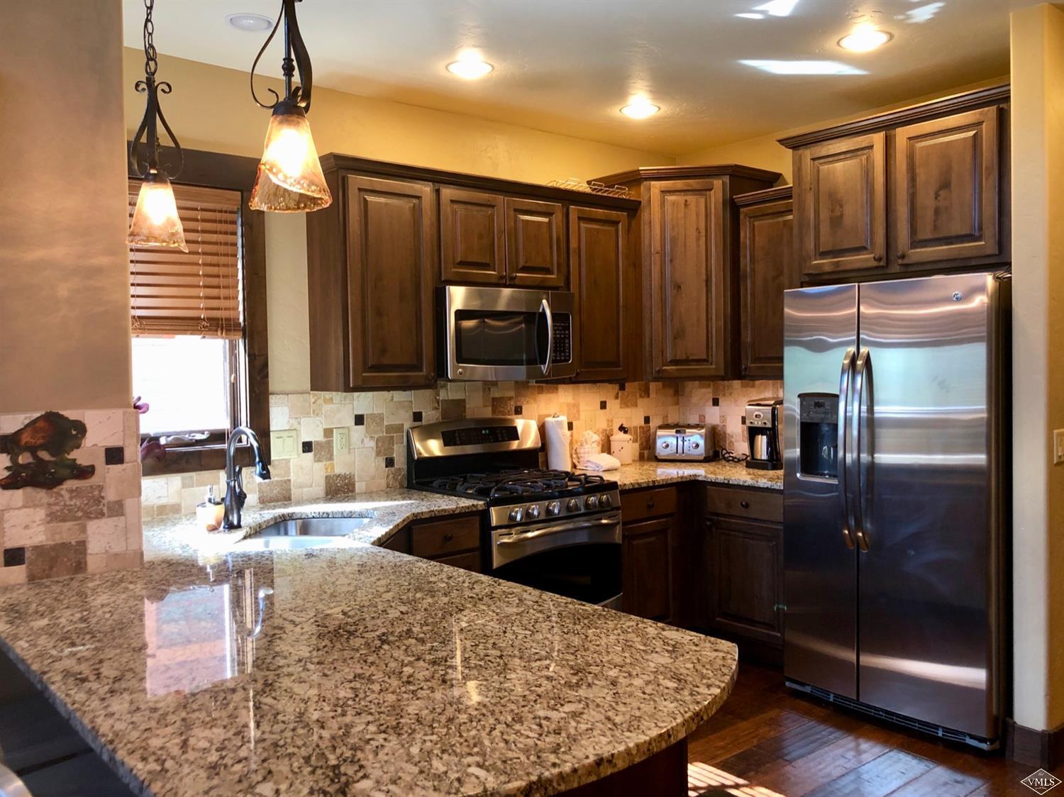 60 County Road, Unit 60A Silverthorne, CO 80497 - Photo 1 of 21 a kitchen with wooden cabinets and stainless steel appliances