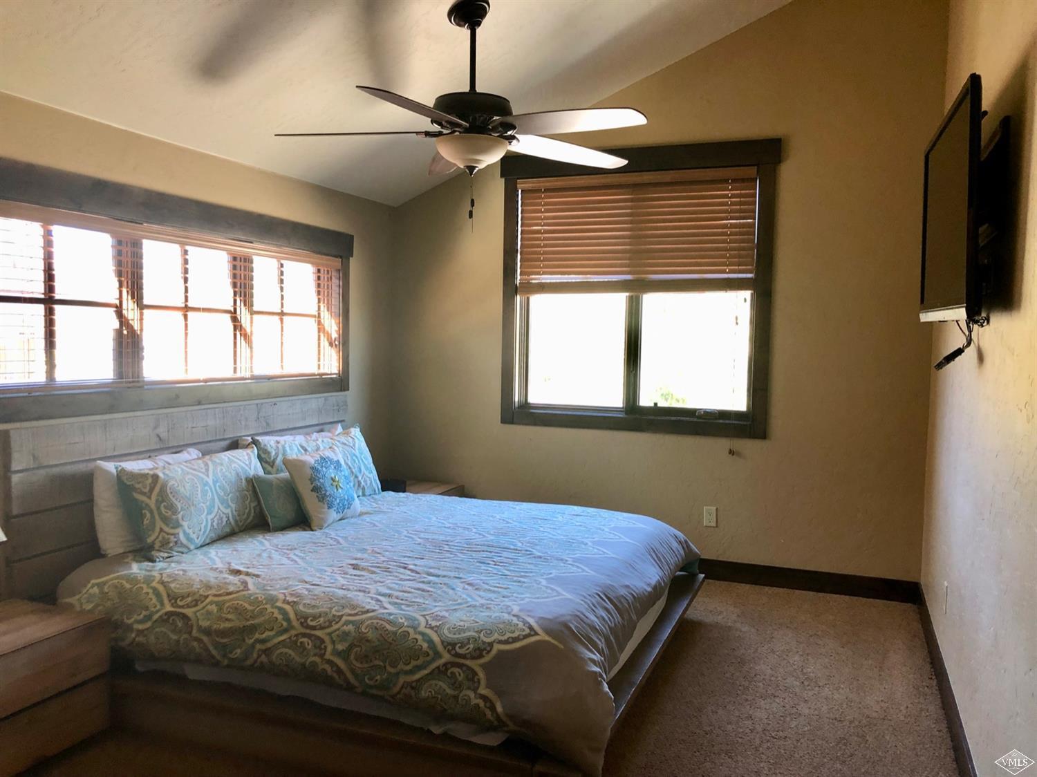 60 County Road, Unit 60A Silverthorne, CO 80497 - Photo 7 of 21 a bedroom with a large bed and a flat tv screen