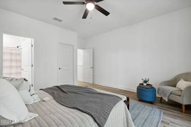 a bedroom with a bed and wooden floor