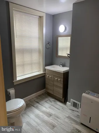 a bathroom with a sink a toilet and a mirror