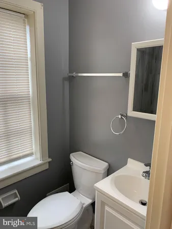 a bathroom with a toilet a sink and a window
