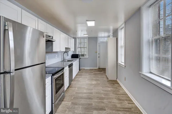 a kitchen with stainless steel appliances a refrigerator a sink a stove a microwave and cabinets