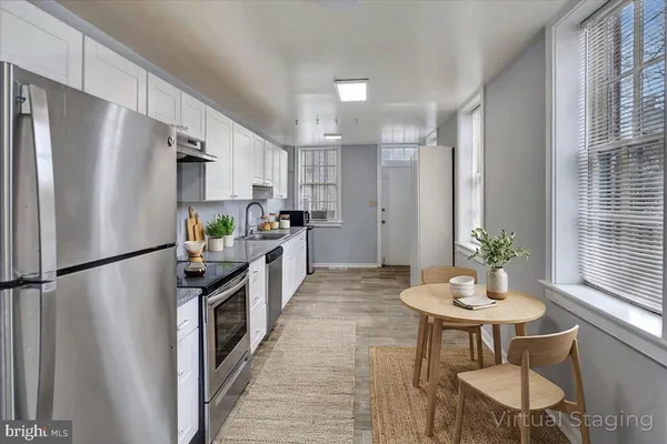 a kitchen with stainless steel appliances a refrigerator and a dining table