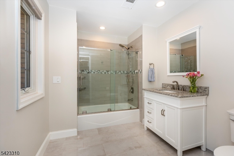 26 Mountain Ridge Drive Livingston, NJ 07039 - Photo 30 of 39 a bathroom with a granite countertop sink a mirror and a shower