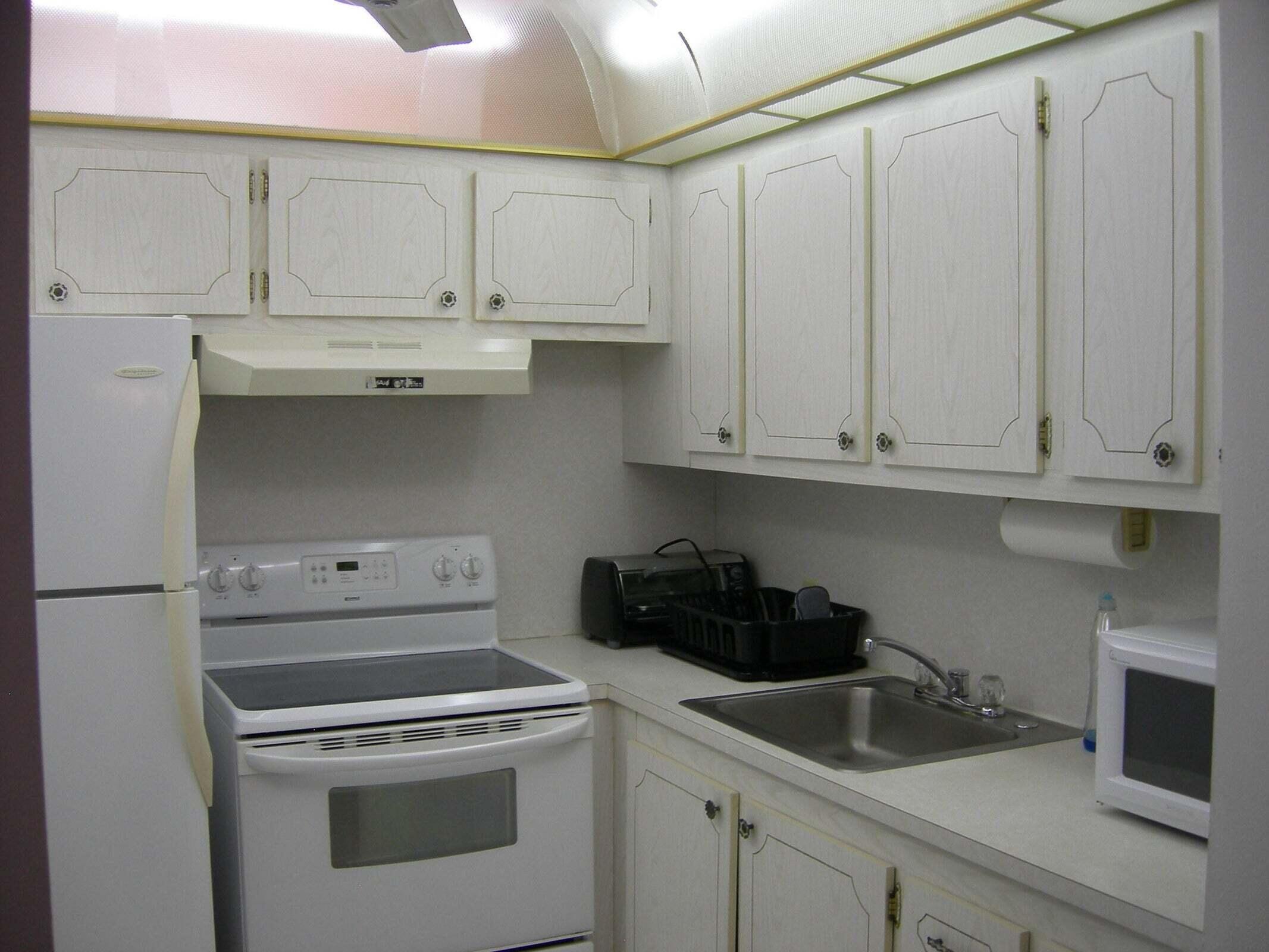 567 Fanshaw North Boca Raton, FL 33434 - Photo 2 of 8 a kitchen with white cabinets and white appliances