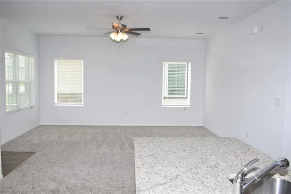 a view of a kitchen with a sink and dishwasher with white walls