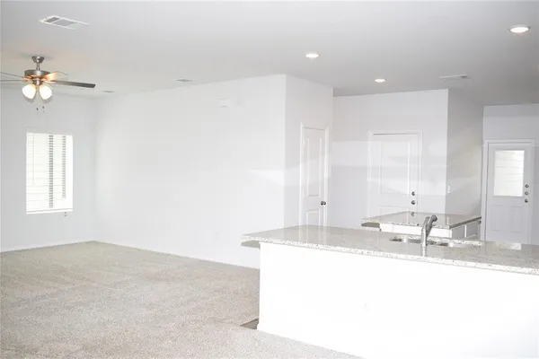 a kitchen with a sink wooden floor and white cabinets
