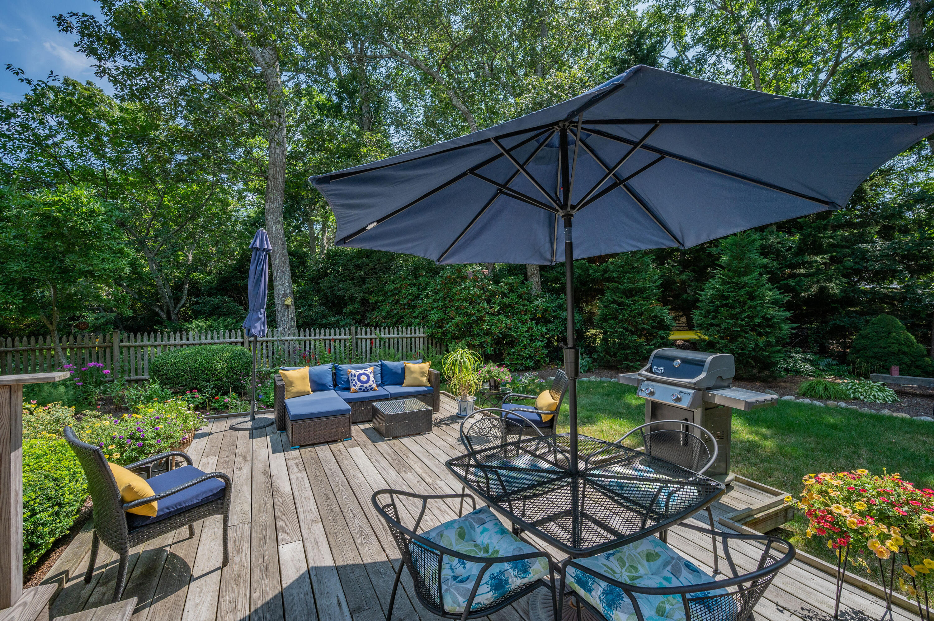 25 Massasoit Trail Eastham, MA 02642 - Photo 24 of 28 a view of a patio with couches table and chairs under an umbrella