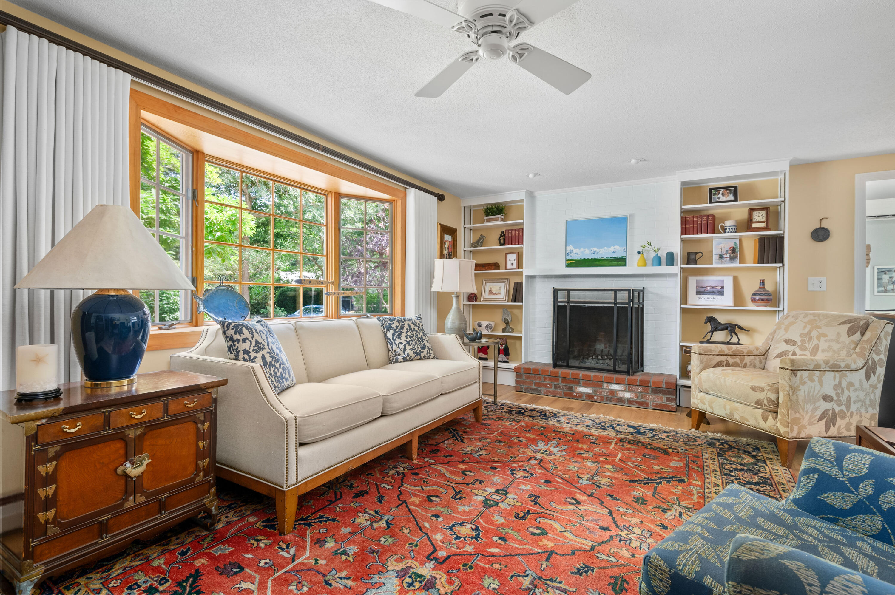 25 Massasoit Trail Eastham, MA 02642 - Photo 6 of 28 a living room with furniture a fireplace and a flat screen tv