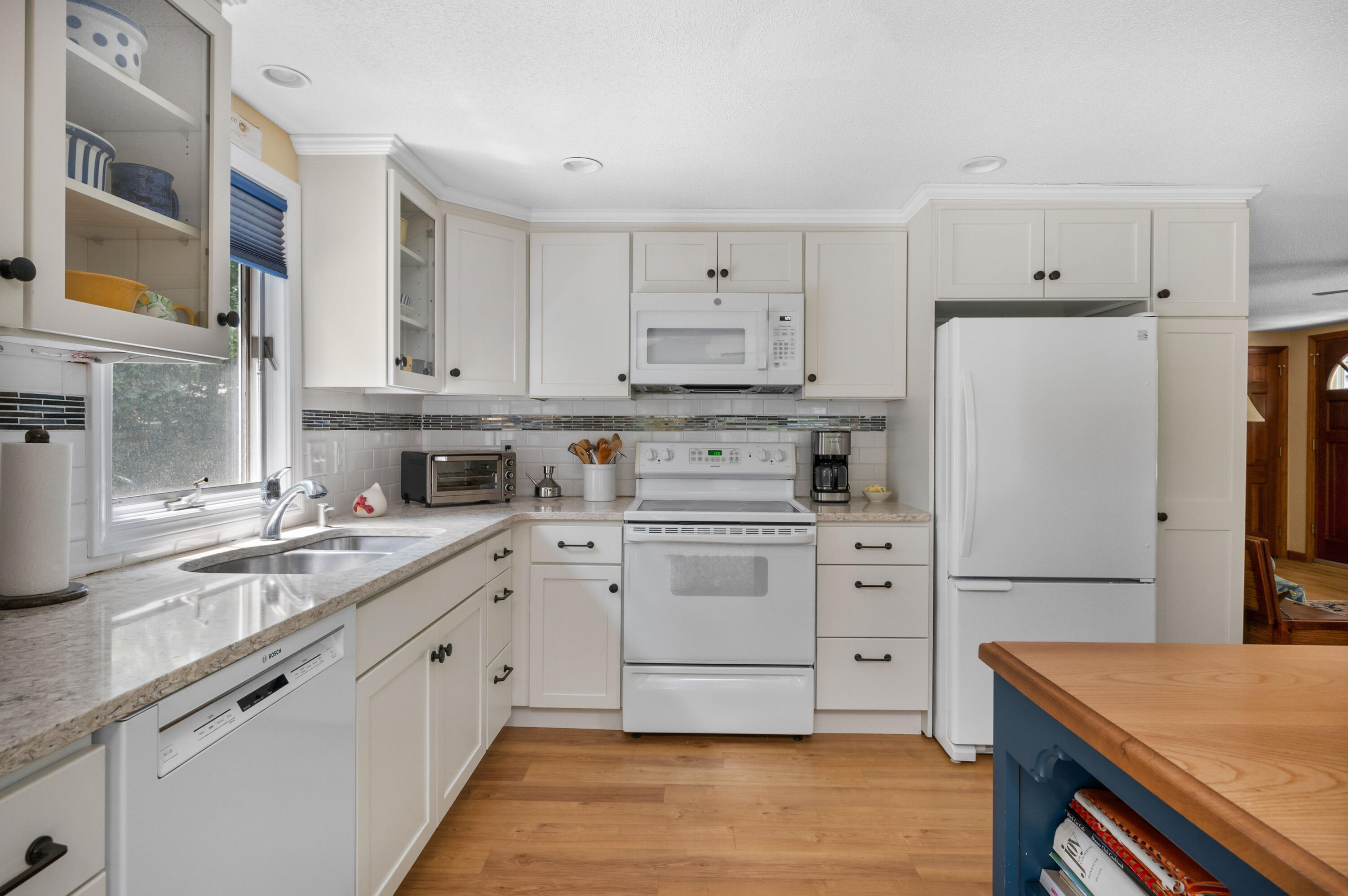 25 Massasoit Trail Eastham, MA 02642 - Photo 8 of 28 a kitchen with white cabinets and white appliances